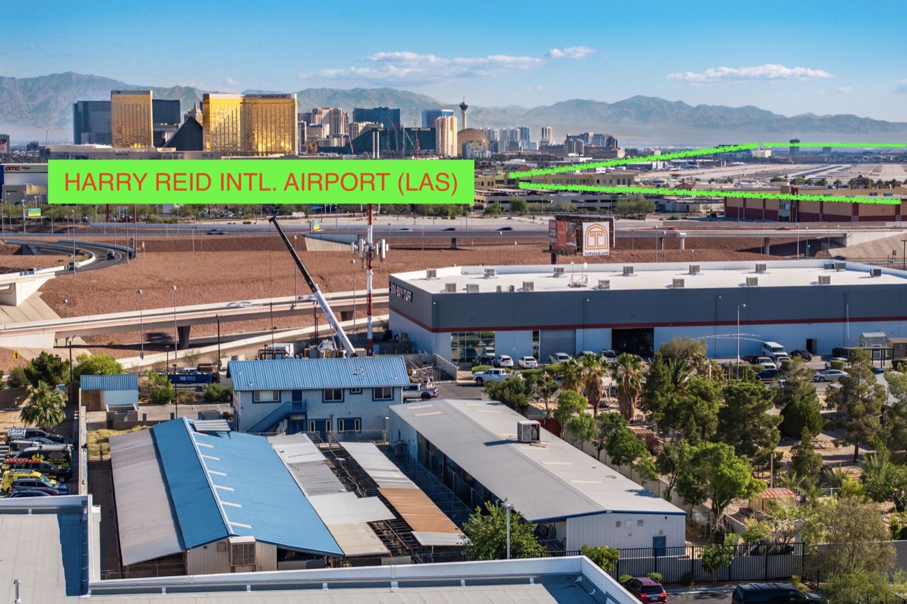 Aerial frame from a documented commercial drone operation inside Class B airspace: a green annotation box outlines Harry Reid International Airport (LAS) in the distance, photographed from about one nautical mile off its runways, with the Las Vegas valley below